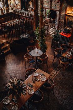 an overhead view of a restaurant with wooden tables and chairs, plants on the table