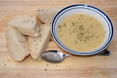 a bowl of soup next to some slices of bread