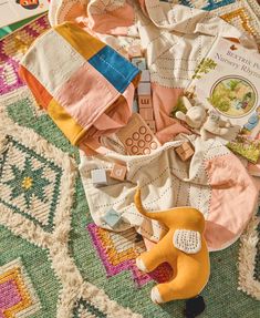 an assortment of clothing and toys on a rug