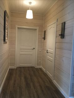 an empty room with wood floors and white walls, two lights on the side of the door