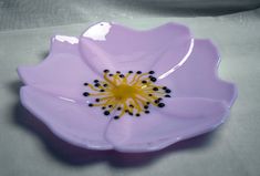 a purple flower shaped dish sitting on top of a table