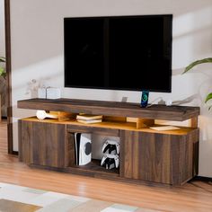 a flat screen tv sitting on top of a wooden entertainment center