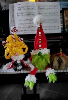 three stuffed animals sitting on top of a piano next to an open sheet music book