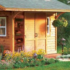 a small wooden shed sitting on top of a lush green field