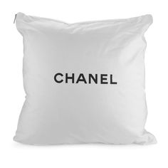 a white pillow with the word chanel on it in black ink, against a white background