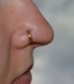 a woman's nose with an orange ring on top of her nose and the bottom part of her nose