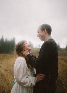 a man standing next to a woman in a field