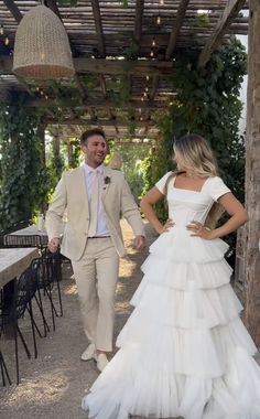 the bride and groom are walking down the path