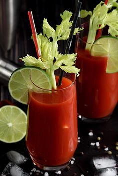 two glasses filled with red liquid and garnished with cilantro