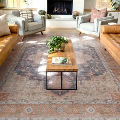 a living room with couches, chairs and a rug on the floor in front of a fireplace