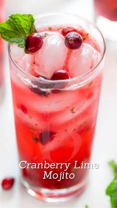 cranberry lime mojito with mint garnish in a glass on a white table