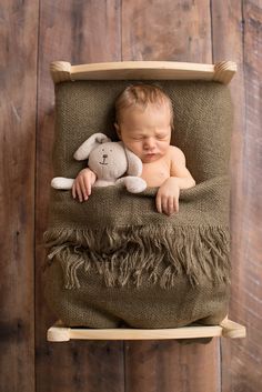 a baby sleeping in a chair with a stuffed animal