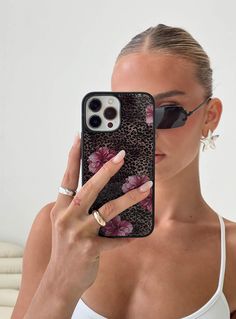 a woman holding up her phone case in front of her face