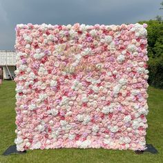 a pink and white flowered wall in the grass