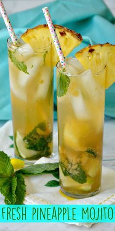 two glasses filled with pineapple mojitas on top of a white plate