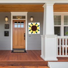 a front porch with a wooden door and white pillars