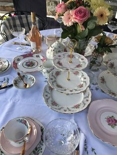 the table is set with dishes, cups and saucers for tea or desserts