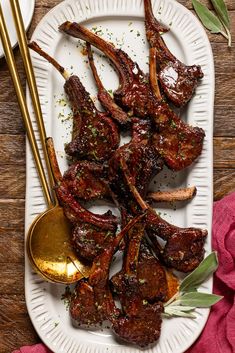 a white plate topped with ribs covered in sauce