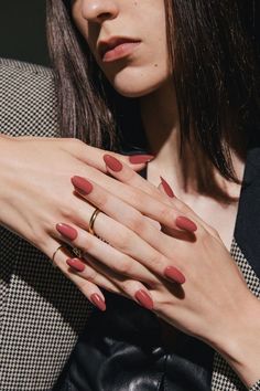 a woman with red nails and a ring on her finger is posing for the camera