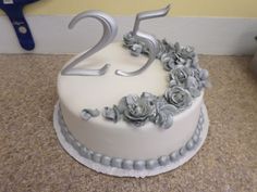 there is a white cake with flowers on the top and number twenty five on the bottom