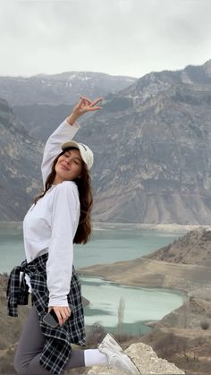 a woman is doing yoga on top of a mountain