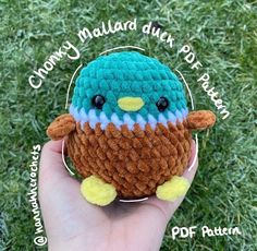 a hand holding a small crocheted bird on top of green grass with words above it