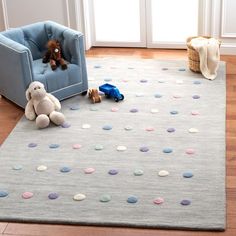 a child's room with a blue chair, teddy bear and stuffed animals on the floor