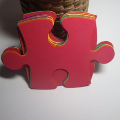 a pink puzzle piece sitting next to a basket