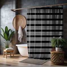 a black and white striped shower curtain next to a bathtub with a plant in it