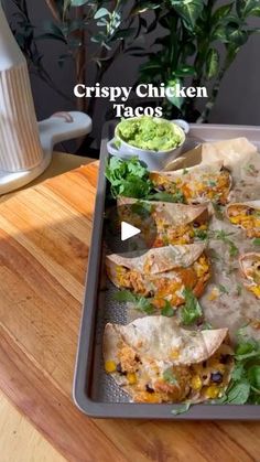 crispy chicken tacos on a tray with guacamole in the background