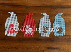 three cross stitched bottles sitting next to each other on a wooden table with the word love spelled in red, white and blue