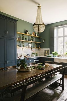 an image of a kitchen setting with wooden table and bench in the foreground, open shelves on the wall