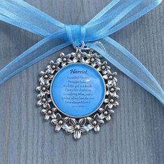 a blue ribbon is tied around a silver ornament with a poem on it