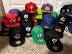 a bunch of hats sitting on the floor in front of a door with other caps