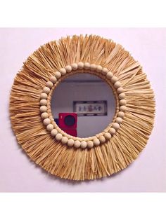 a mirror made out of straw and wood beads