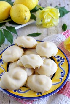 lemon meringue cookies on a yellow and blue plate next to some fresh flowers