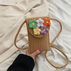 a woman's hand holding a purse with flowers on it