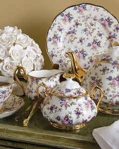 a table topped with plates and cups filled with flowers