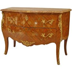 an ornately decorated wooden chest with gold leaf decoration on the top and bottom drawers