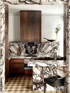 a kitchen with marble counter tops and wooden cabinetry, along with a checkered floor