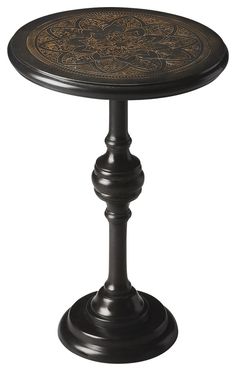 a black table with an ornate design on it's top and base, against a white background