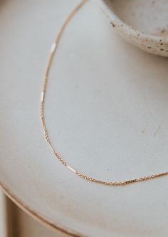 Delicate textured bars are linked together with delicate chain to add a little whimsical sparkle. Offered in 16" or 18" lengths. Available in 14kt Gold Fill + Sterling Silver. KJ styles her Mari Chain with our Lenny Chain and Tiny Freshwater Pearl Necklace. Love this chain? Check out our Mari Choker and Mari Bracelet. Handmade in Eau Claire, WI. Our jewelry is handmade so each piece will be unique and may vary slightly from what is pictured. Gold Dainty Bar Necklace With Cable Chain, Dainty Gold Bar Necklace With Cable Chain, Everyday 14k Gold Bar Necklace With Adjustable Chain, Dainty Bar Necklace With Satellite Chain, Everyday 14k Gold Bar Necklace With Delicate Chain, 14k Gold Bar Necklace With Delicate Chain, Gold Bar Necklace With Delicate 14k Chain, Delicate Gold Bar Necklace In 14k, Gold Bar Necklace With Delicate Chain In 14k Gold