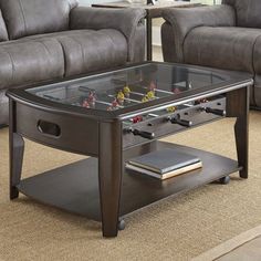 a living room with two couches and a coffee table that has foosball on it