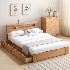 a bed sitting in a bedroom next to a dresser with drawers on each side and two pictures above it