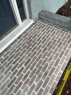 a brick walkway being laid in front of a door