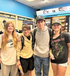 four young people are posing for a photo in a store with their arms around each other