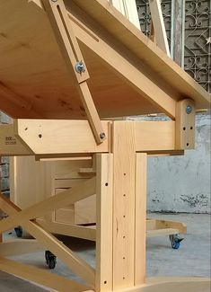 a wooden work bench sitting on top of a hard wood floor