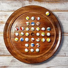 a wooden board with several different colored balls on it and one is in the shape of a circle