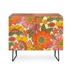 an orange and yellow floral cabinet with black legs