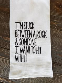 a tea towel with the words i'm stuck between a rock and someone i want to hit with